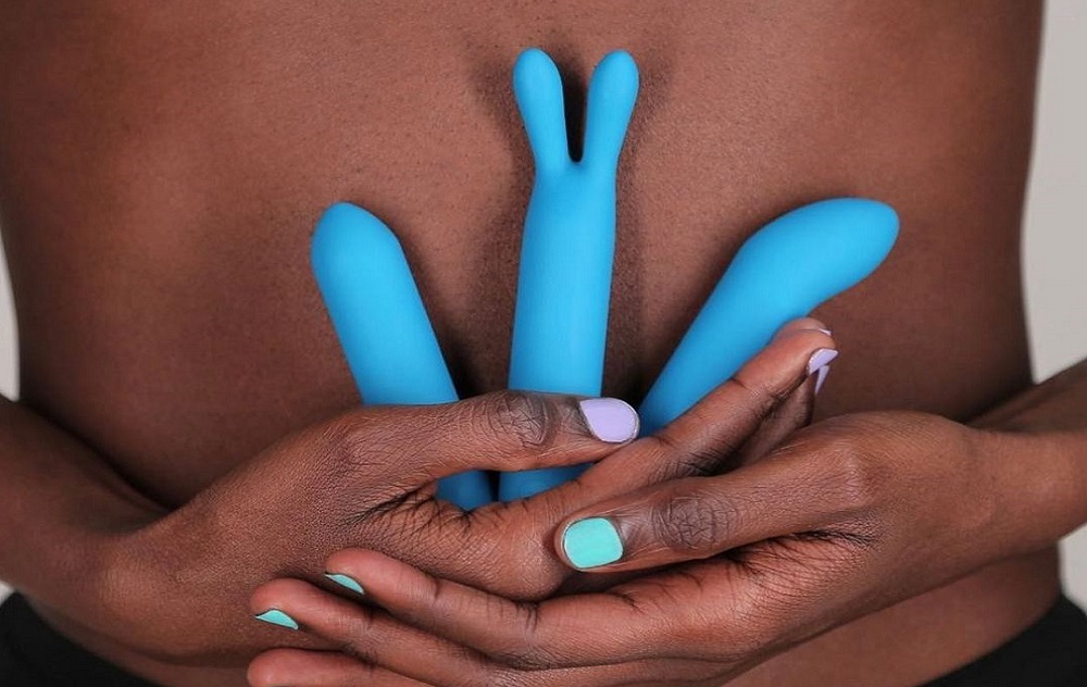 woman holding three blue vibrators in her hands